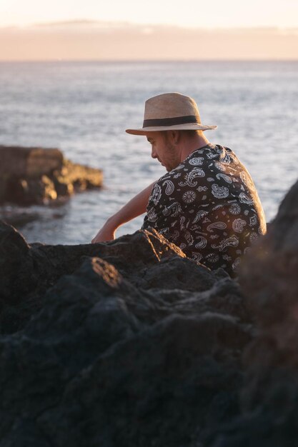 Garçon songeur s'asseyant devant la mer