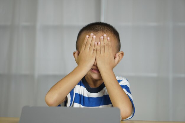 Ce garçon souffre de fatigue oculaire à force de regarder un ordinateur pendant une longue période