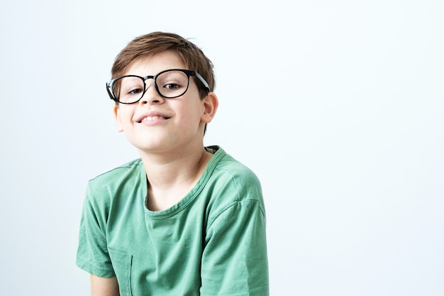 Garçon souriant dans un t-shirt vert et des lunettes