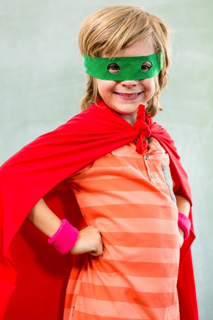 Garçon souriant habillé en super-héros en classe