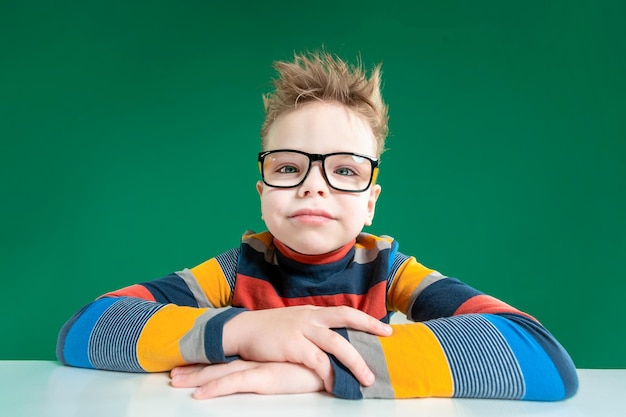 Garçon souriant avec des lunettes fond vert