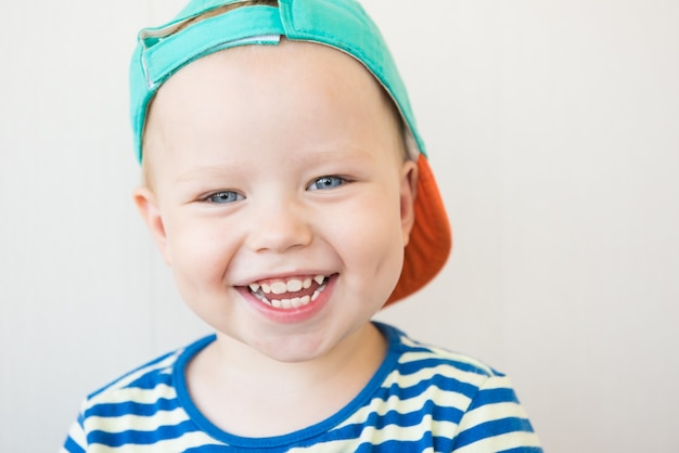 Garçon souriant en t-shirt rayé.