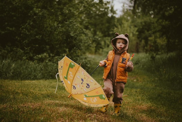 un garçon sous la pluie un enfant avec un parapluie nature