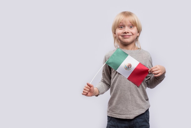 Garçon surpris avec le drapeau du Mexique en mains.