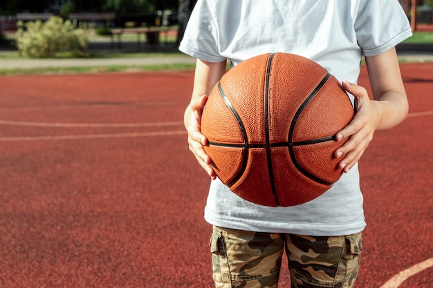 Le garçon tient dans ses mains un gros plan de basket