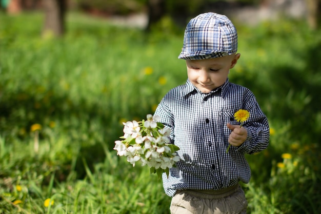 un garçon tient des fleurs dans ses mains