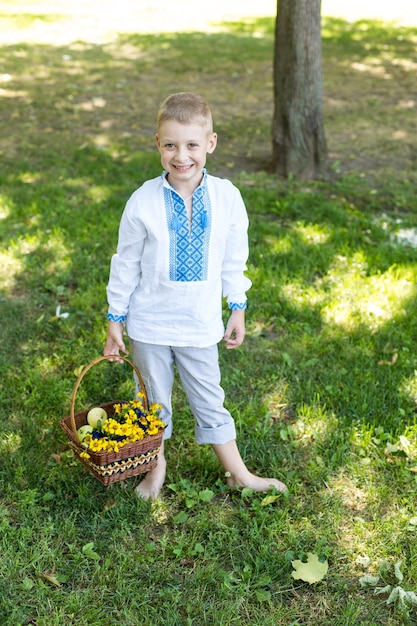 Un garçon tient un panier de fleurs et un panier de fleurs.