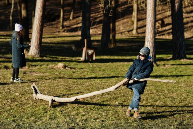 Un garçon tire un arbre dans un parc ensoleillé au printemps