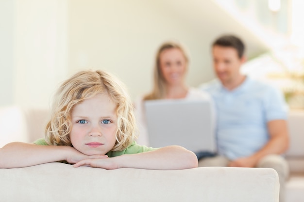 Garçon triste avec les parents en arrière-plan