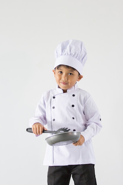 Un garçon en uniforme de chef