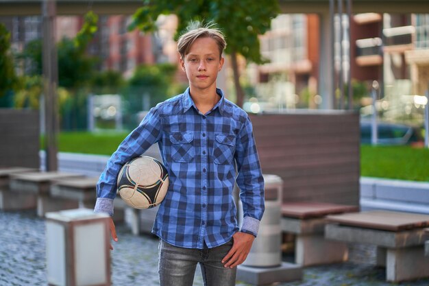 Le garçon va jouer au football avec des amis.