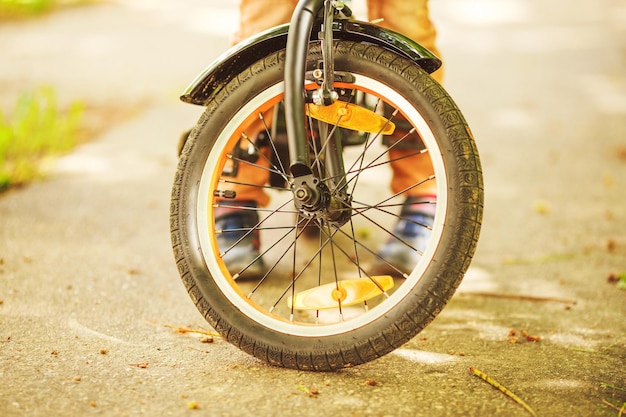 Garçon avec un vélo sur la roue de rue d'un vélo pour enfants