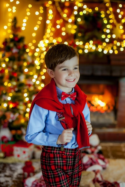 Un garçon vêtu d'un pull sur fond de belles guirlandes de Noël festives