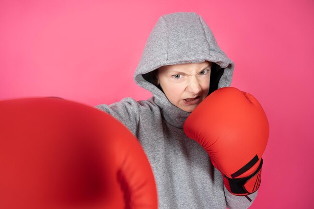 Garçon violent portant un sweat à capuche et des gants de boxe