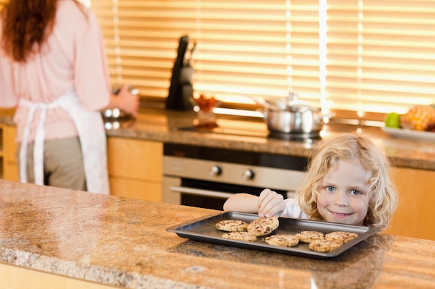 Garçon volant un biscuit pendant que sa mère ne regarde pas