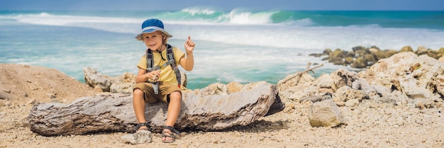 Garçon voyageur sur l'étonnante plage de Melasti aux eaux turquoises, île de Bali en Indonésie. Voyager avec des enfants concept BANNIÈRE, FORMAT LONG