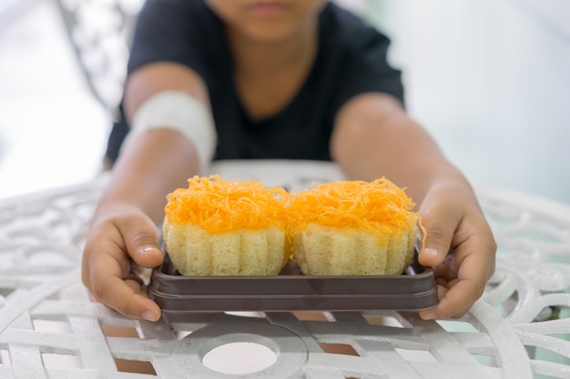 Photo les garçons aux mains blessées tiennent un jaune d'oeuf d'or