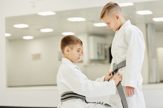 Garçons nouant la ceinture sur un kimono