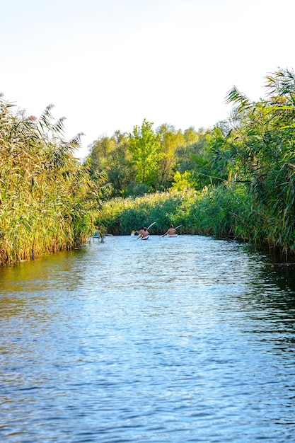 Les garçons pagayent des canoës sur la rivière