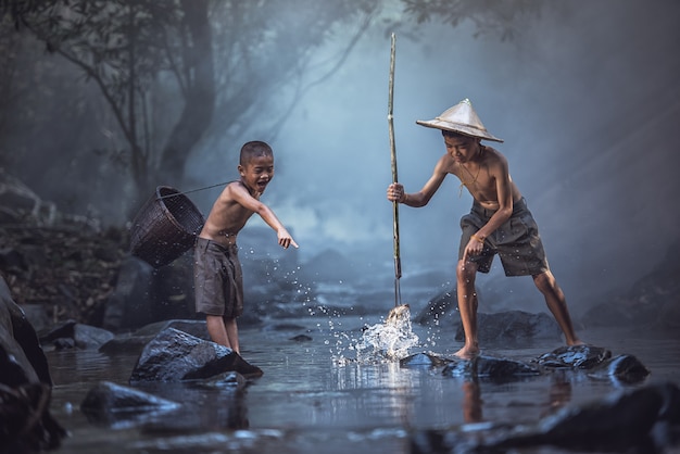 Garçons de pêche pêchant dans la rivière, campagne de Thaïlande