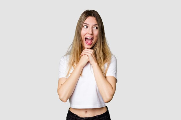 Garde les mains sous le menton regarde joyeusement de côté