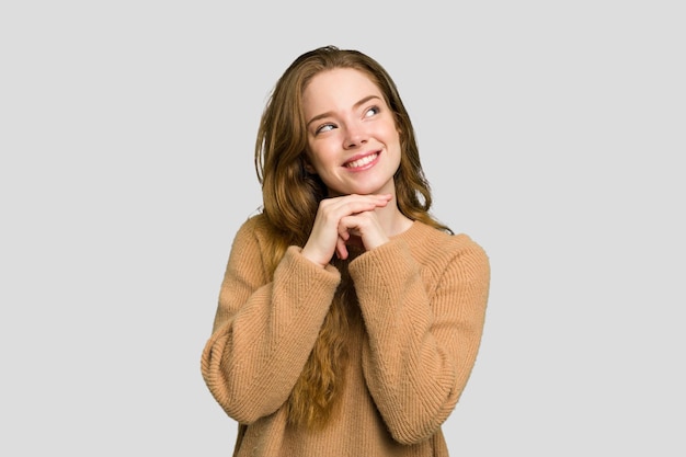 Garde les mains sous le menton regarde joyeusement de côté