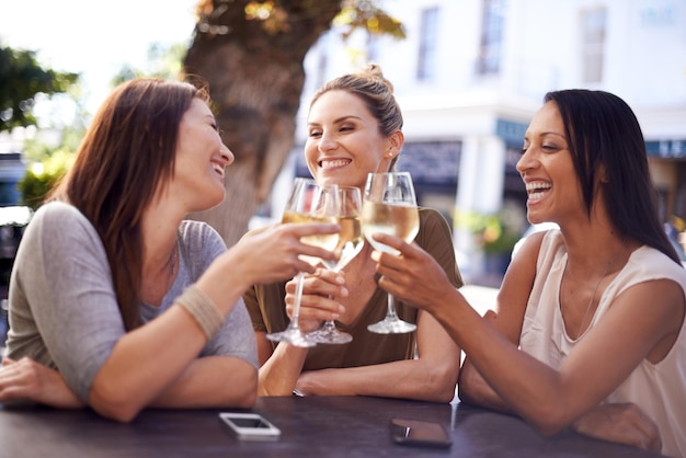 Gardez vos amis près de vous Photo d'un joyeux groupe d'amis prenant un verre ensemble