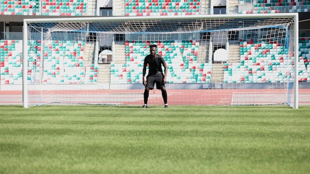 Le gardien de but de football attrape la balle dans le stade