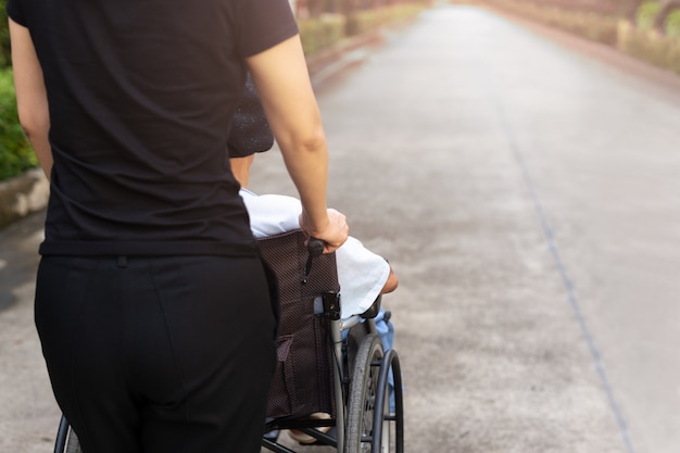 Gardien de passer du temps en plein air avec un patient en fauteuil roulant