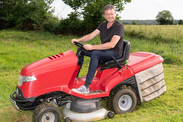 Gardner homme sur tondeuse autoportée jardinier dans le jardin