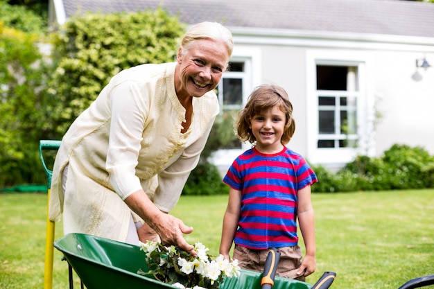 Garndmother and boy with flower pots in brouette