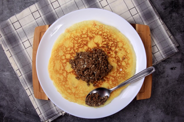 Garniture de viande hachée sur une grande crêpe fine. Faire une crêpe fourrée à la viande ou au coeur