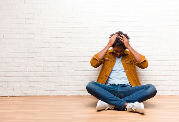 un gars afro-américain assis se sentant stressé et frustré