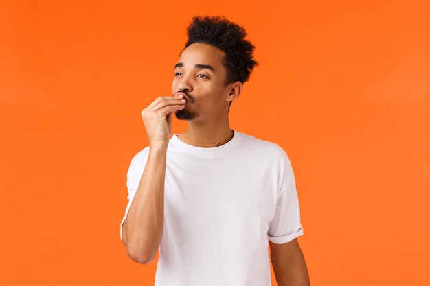 gars afro-américain avec moustache et coupe de cheveux afro embrasser les doigts et donner l'appréciation