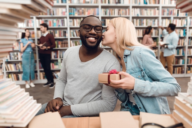 Gars américain et fille blanche entourée de livres.