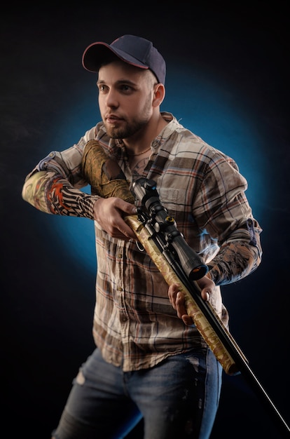 Le gars en chemise avec le fusil