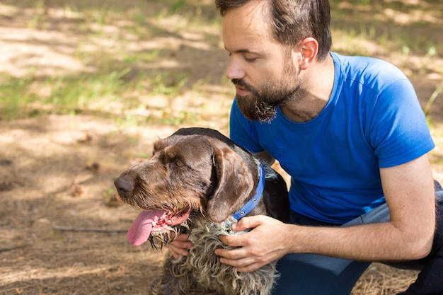 Le gars avec le chien dans le parc chien de garde de chasse allemand drahthaar