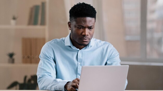 Un gars en colère agacé un homme afro-américain, un patron masculin insatisfait a un problème avec l'ordinateur