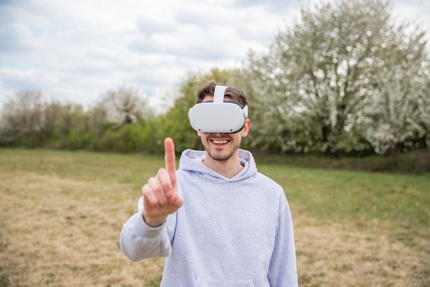 un gars dans un champ s'amuse en utilisant un casque vr