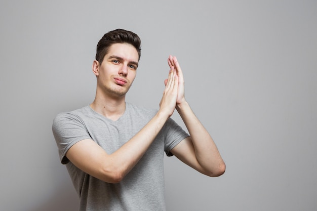 Un gars dans un T-shirt gris avec des émotions sur son visage.