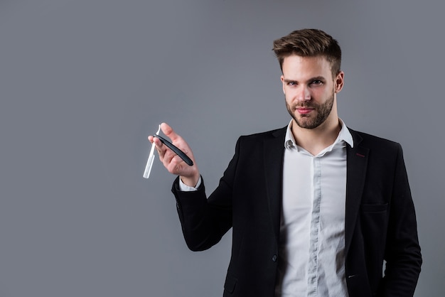 Un gars élégant avec une coiffure à la mode porte un costume de bureau avec une lame de rasoir, un salon de coiffure.