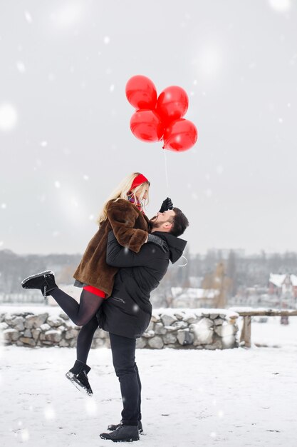 Le gars encercle sa petite amie dans ses bras le jour de la Saint-Valentin