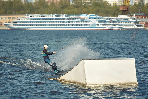 Le gars fait du wakeboard sur la rivière. Sports actifs et extrêmes.