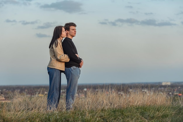 un gars et une fille amoureux embrassant regardent une belle vue sur la nature devant eux