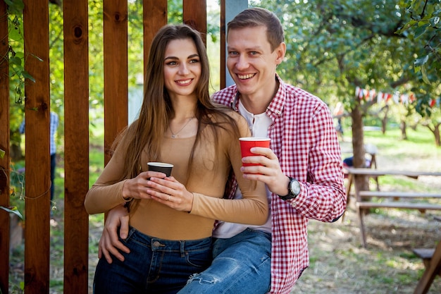 Un gars et une fille boivent du café dans le parc sur la terrasse d'un café