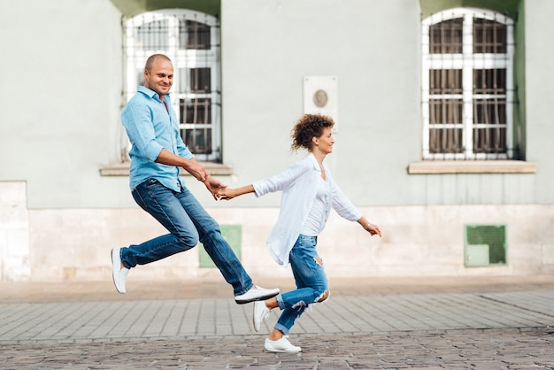 Un gars et une fille marchent joyeusement le matin dans les rues vides de la vieille Europe