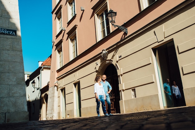 Un gars et une fille marchent joyeusement le matin dans les rues vides de la vieille Europe