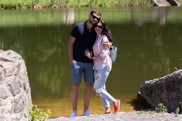 Un gars avec une fille près du lac portant des lunettes en été