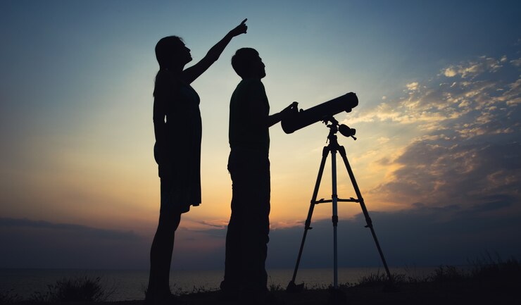 Photo le gars avec la fille regardant le ciel à travers un télescope