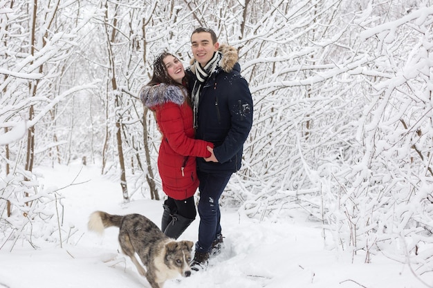 Le gars et la fille se reposent dans les bois d'hiver Mari et femme dans la neige Jeune couple marchant dans le parc d'hiver